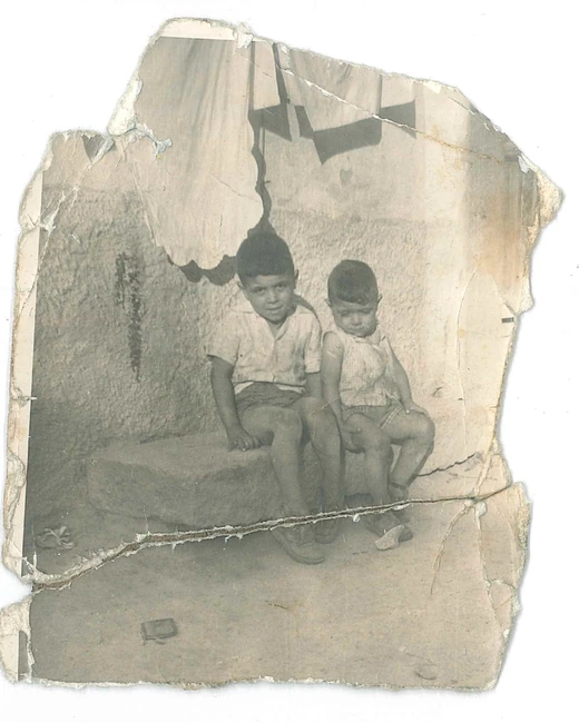 Antes: fotografía rota de dos niños, con grietas y zonas deterioradas